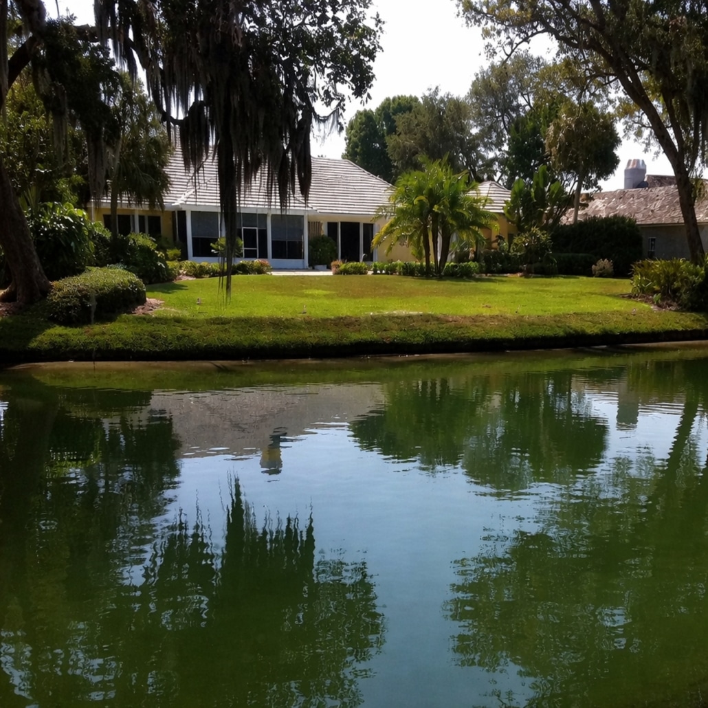 Residential shoreline with landscaped waterfront property and calm lagoon illustrating shoreline restoration and erosion control environment.